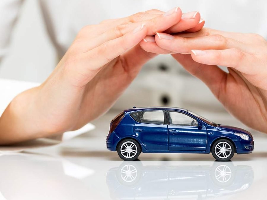 Hands sheltering a small blue car