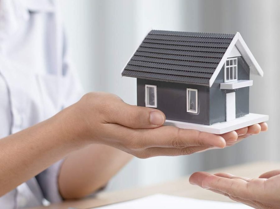 Hands holding a model house